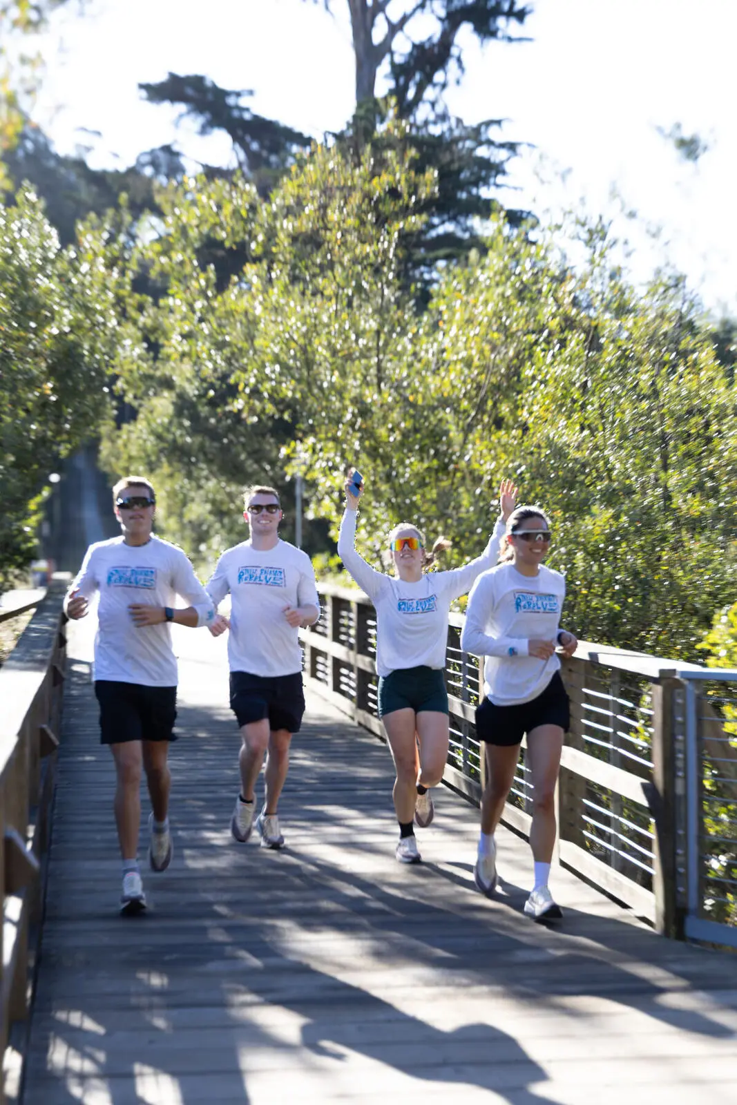 A team running across a wooden bridge in the Presidio