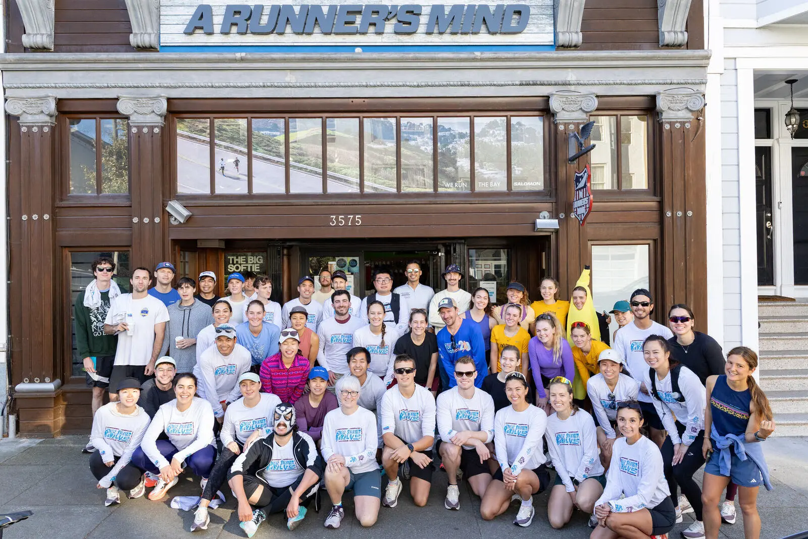 A big group of runners in matching long sleeves outside A Runner's Mind SF