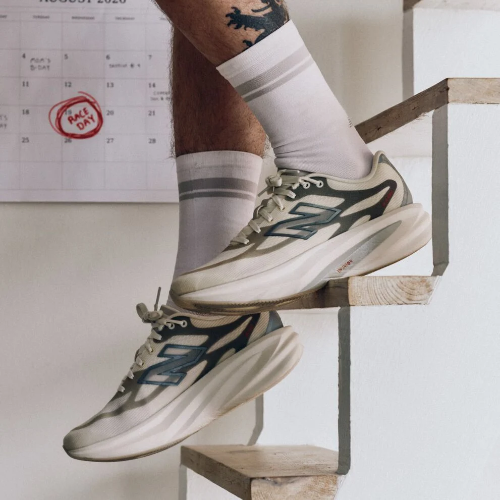 A runner in New Balance SuperComp Rebels stepping down a staircase, with 'Race Day' circled on the calendar behind